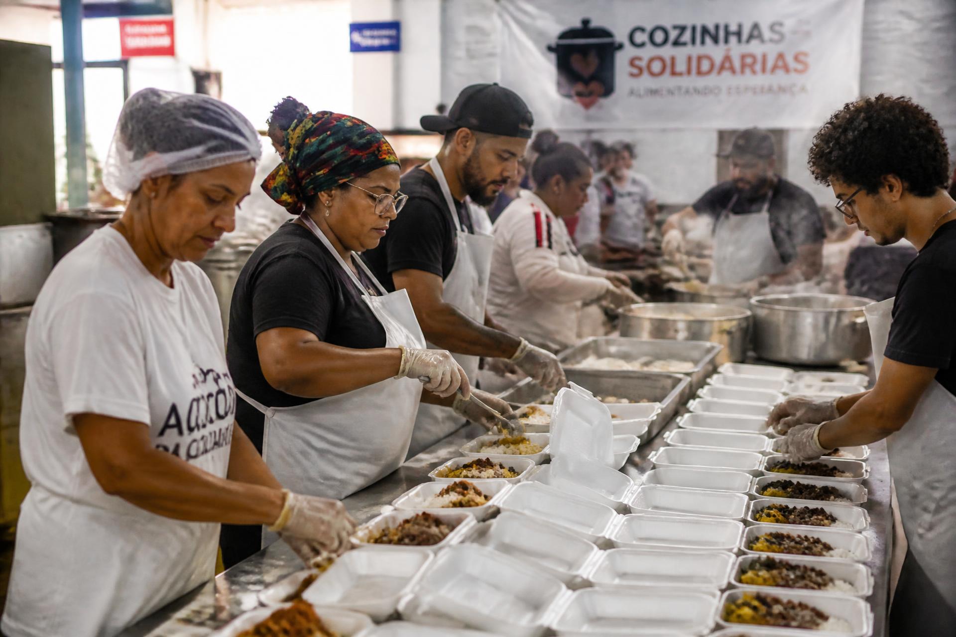 Voluntários montando centenas de marmitas em cozinha social do Instituto Brasileiro Campeão
